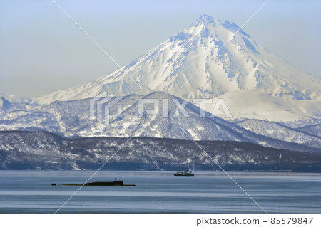 Landscape with view of Avacha Bay with submarine and fishing vessels on the background of volcano. Landscape with view of Avacha Bay with submarine and fishing vessels on the background of volcano. 85579847
