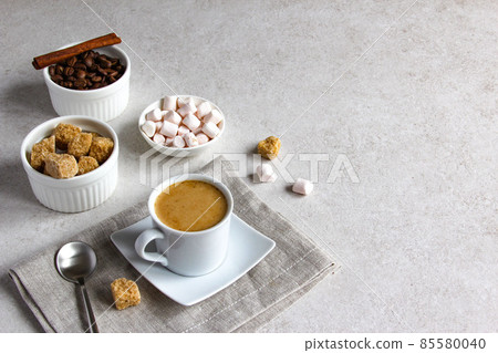 Vanilla coffee with brown sugar and marshmallow. Tasty steam espresso in a cup with coffee beans. 85580040