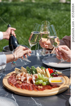 Snack for guests. A plate of cheese, salami, nuts, grapes and snacks on a tray. Snack for guests. A plate of cheese, salami, nuts, grapes and snacks on a tray. 85580064