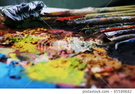 Close up paint brushes on a color full painter in black ground. Close up paint brushes on a color full painter in black ground. 85580682