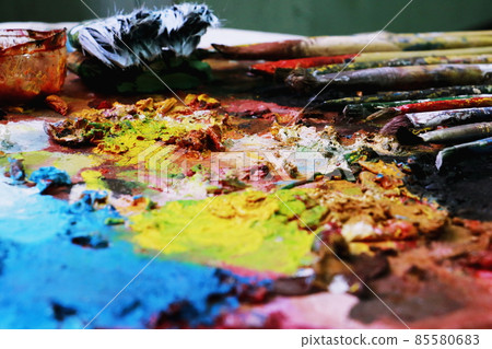 Close up paint brushes on a color full painter in black ground. Close up paint brushes on a color full painter in black ground. 85580683