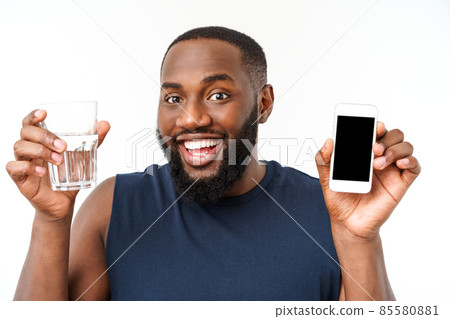 African american male athlete sport man with running sports with mobile phone and drinking water from glass. African american male athlete sport man with running sports with mobile phone and drinking water from glass. 85580881