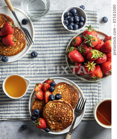 Pancakes with berries on a striped breakfast tablecloth. Top view Pancakes with berries on a striped breakfast tablecloth. Top view 85581080