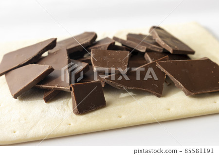Broken chocolate bar and puff pastry. Image of making chocolate pie Broken chocolate bar and puff pastry. Image of making chocolate pie 85581191