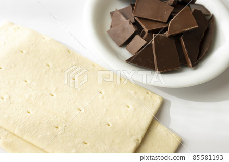 Broken chocolate bar and puff pastry. Image of making chocolate pie 85581193