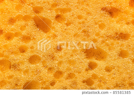 Foam sponge texture in macro. Textured background. Dishwashing or car cleaning concept. Abstract yellow wallpaper or backdrop for your design closeup  85581385
