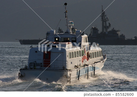 High-speed passenger ship in Kure Port (back view, escort ship silhouette background) 85582600