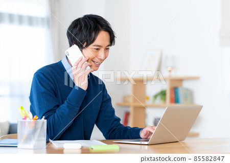 一個年輕人通過遠程辦公打電話 85582847