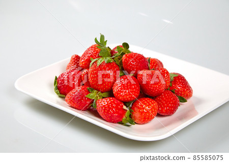 Fresh and tasty fruits and berries on a white bowl Fresh and tasty fruits and berries on a white bowl 85585075