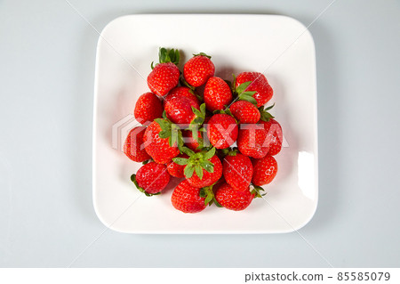Fresh and tasty fruits and berries on a white bowl Fresh and tasty fruits and berries on a white bowl 85585079