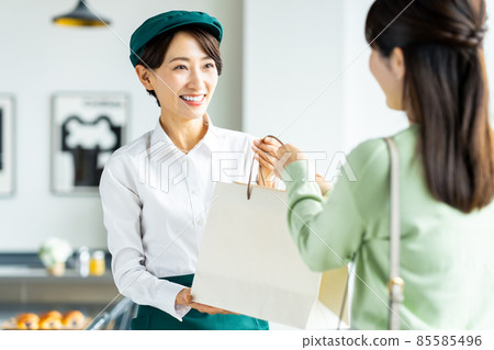 Middle clerk handing over the product Middle clerk handing over the product 85585496