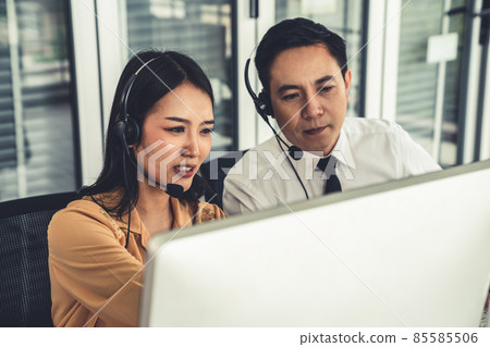 Business people wearing headset working actively in office Business people wearing headset working actively in office 85585506