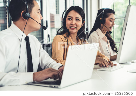 Business people wearing headset working actively in office Business people wearing headset working actively in office 85585560