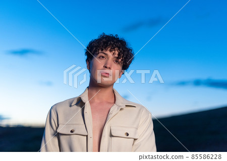 Portrait of non binary male with gaze lost during dusk Portrait of non binary male with gaze lost during dusk 85586228
