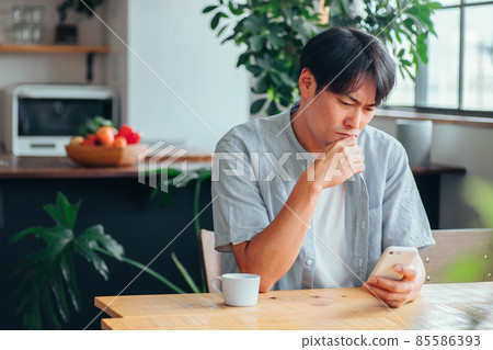 A man who is depressed when he sees a smartphone A man who is depressed when he sees a smartphone 85586393