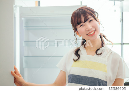 一個女人看著空冰箱(看著相機) 一個女人看著空冰箱(看著相機) 85586605