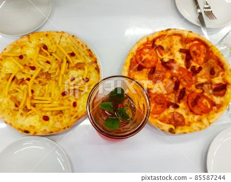 Two pizzas and bottle of strawberry lemonade on a table in cafe. Top view Two pizzas and bottle of strawberry lemonade on a table in cafe. Top view 85587244