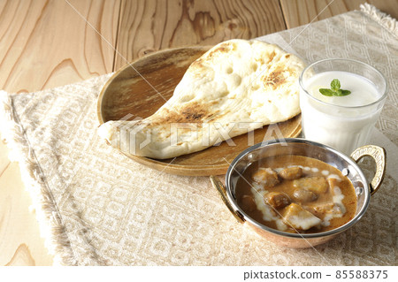 Hot massaman curry, naan and lassie with lots of ingredients such as chicken and peanuts Hot massaman curry, naan and lassie with lots of ingredients such as chicken and peanuts 85588375