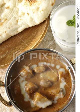 Hot massaman curry, naan and lassie with lots of ingredients such as chicken and peanuts Hot massaman curry, naan and lassie with lots of ingredients such as chicken and peanuts 85588388