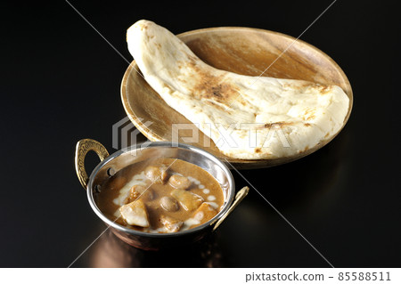 Hot massaman curry and naan with lots of ingredients such as chicken and peanuts taken on a black background Hot massaman curry and naan with lots of ingredients such as chicken and peanuts taken on a black background 85588511