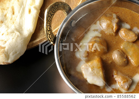 鳥瞰熱馬薩曼咖哩和馕，在黑色背景上有很多配料，如雞肉和花生 85588562