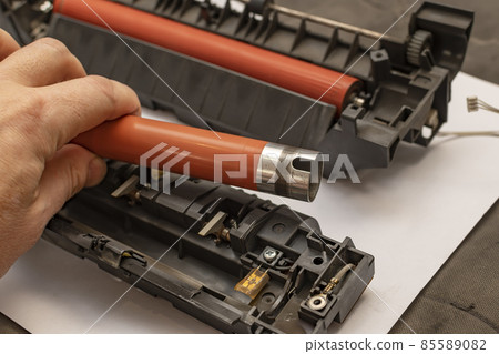 view of a worn out upper heating shaft, roller from a printer in the hand of a person 85589082