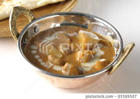 Hot massaman curry and naan with lots of ingredients such as chicken and peanuts taken on a white background 85589587