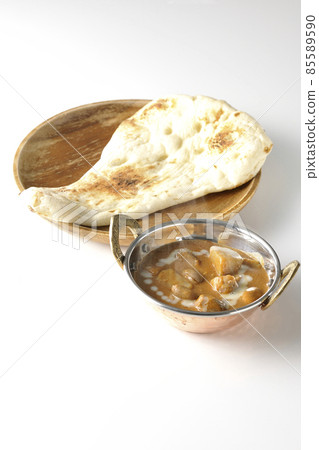Hot massaman curry and naan with lots of ingredients such as chicken and peanuts taken on a white background Hot massaman curry and naan with lots of ingredients such as chicken and peanuts taken on a white background 85589590