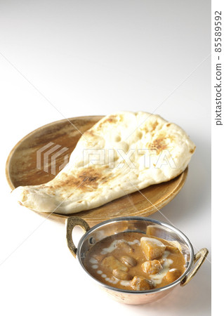 Hot massaman curry and naan with lots of ingredients such as chicken and peanuts taken on a white background Hot massaman curry and naan with lots of ingredients such as chicken and peanuts taken on a white background 85589592
