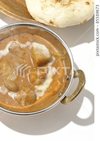 A bird's-eye view of hot massaman curry and naan containing many ingredients such as chicken and peanuts on a white background A bird's-eye view of hot massaman curry and naan containing many ingredients such as chicken and peanuts on a white background 85589673
