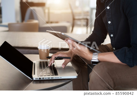 Business tablet on office desk with laptop and man working at office. Business tablet on office desk with laptop and man working at office. 85590842