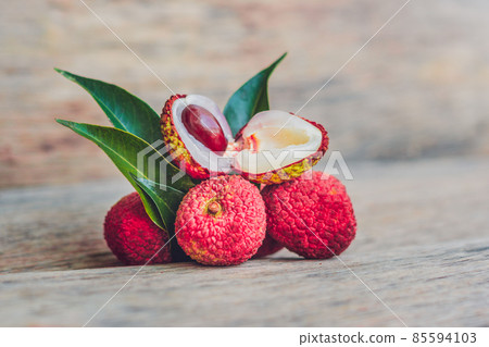 Fresh litchi fruit on an old wooden background Fresh litchi fruit on an old wooden background 85594103
