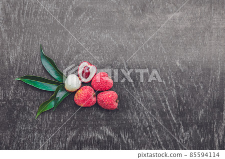 Fresh litchi fruit on an old wooden background Fresh litchi fruit on an old wooden background 85594114