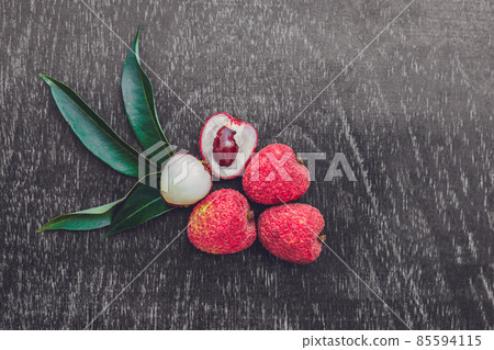 Fresh litchi fruit on an old wooden background Fresh litchi fruit on an old wooden background 85594115
