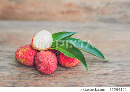 Fresh litchi fruit on an old wooden background Fresh litchi fruit on an old wooden background 85594121