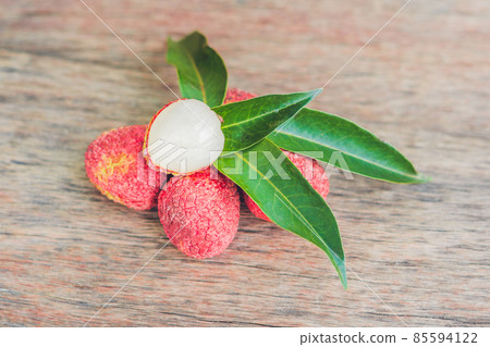 Fresh litchi fruit on an old wooden background Fresh litchi fruit on an old wooden background 85594122