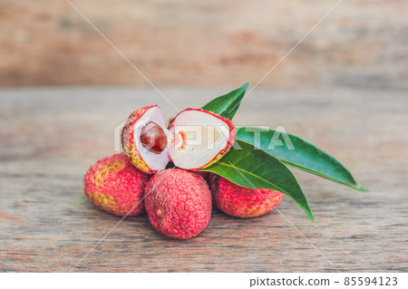 Fresh litchi fruit on an old wooden background Fresh litchi fruit on an old wooden background 85594123