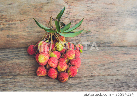 Fresh litchi fruit on an old wooden background Fresh litchi fruit on an old wooden background 85594154