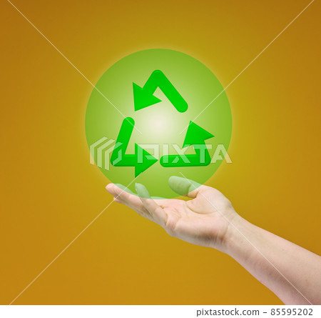 female hand holds recycling icon on yellow background. Responsible attitude to nature resources female hand holds recycling icon on yellow background. Responsible attitude to nature resources 85595202
