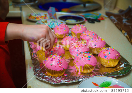 Freshly baked vanilla muffins are garnished with sweet icing and topping. Freshly baked vanilla muffins are garnished with sweet icing and topping. 85595713