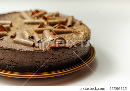 Digestive biscuit base with chocolate cheesecake and pockets of salted caramel sauce, topped with chocolate ganache, milk chocolate curls, and gold shimmer Digestive biscuit base with chocolate cheesecake and pockets of salted caramel sauce, topped with chocolate ganache, milk chocolate curls, and gold shimmer 85596515