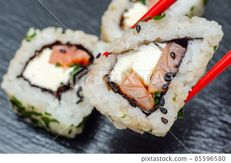 Closeup of smoked salmon, soft cheese and chive California roll 85596580