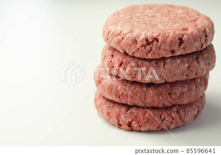 Raw beef burgers with a pinch of salt and black pepper on the white background Raw beef burgers with a pinch of salt and black pepper on the white background 85596641
