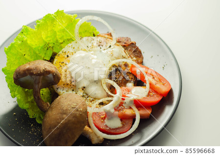 The fried portion of gammon served with egg, fresh lettuce, tomato, onion and funguses 85596668