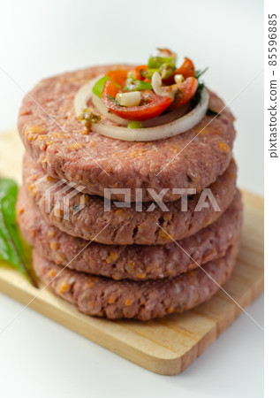 Raw beef burgers blended with caramelised red onion and tangy red Leicester cheese prepared for grilling Raw beef burgers blended with caramelised red onion and tangy red Leicester cheese prepared for grilling 85596885