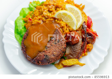Meat free burger and long grain rice with red peppers, tomatoes and jalapeno chillies Meat free burger and long grain rice with red peppers, tomatoes and jalapeno chillies 85596913