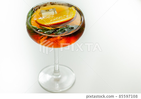 Refreshing cocktail based on gin and champagne and blood orange juice, served with a slice of orange and rosemary 85597108