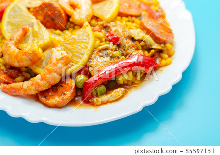 Delicious paella, cooked risotto rice with chicken thigh, king prawns, tomatoes and  chorizo 85597131