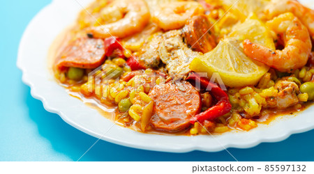 Delicious paella, cooked risotto rice with chicken thigh, king prawns, tomatoes and  chorizo 85597132