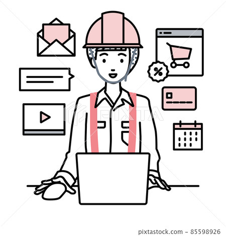 A woman at a construction site sitting at a desk and doing an online shop or marketing job on a PC 85598926